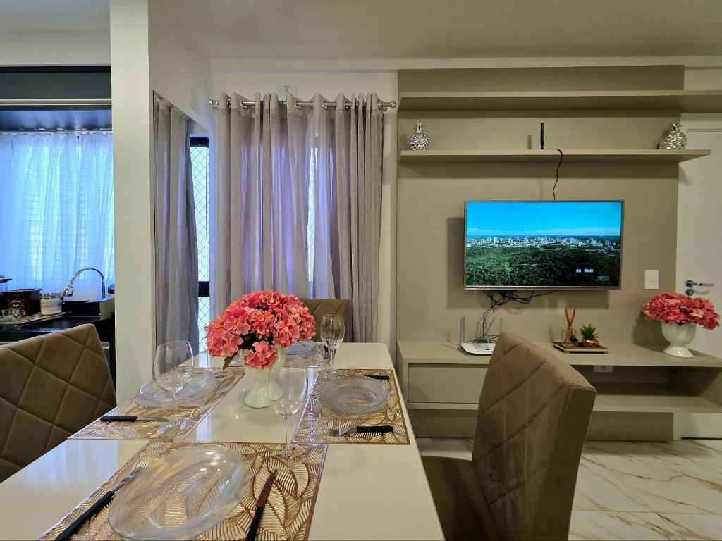 une salle à manger avec une table et une télévision dans l'établissement Apt Novo 2 Quartos 5 min do Centro e Av Cataratas, à Foz do Iguaçu