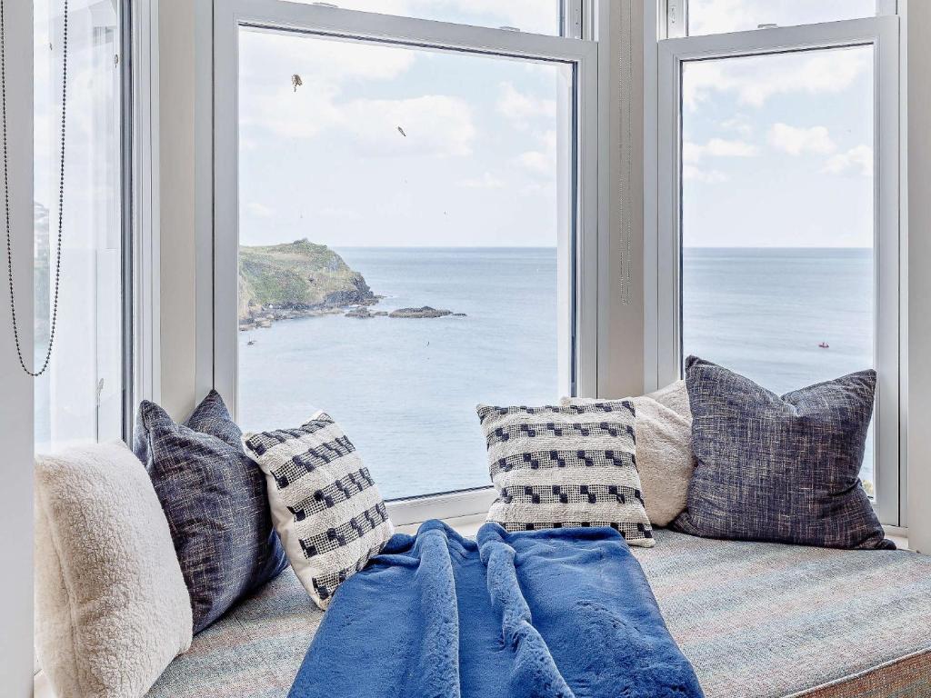a couch in front of a large window with the ocean at 4 Bed in Fowey 82152 in Fowey