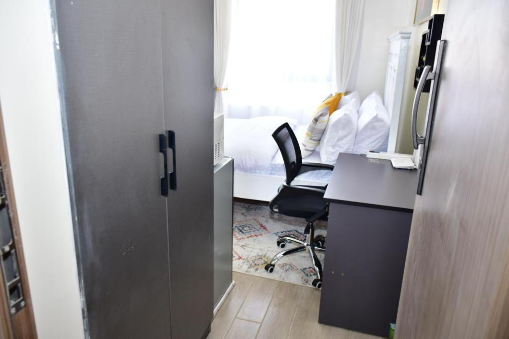 ナイロビにあるOrchard Homesの部屋に机と椅子があるオフィス