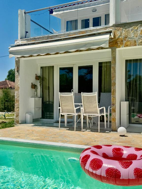 a villa with a swimming pool and a house at Oasis by the Pool in Nea Kallikrateia