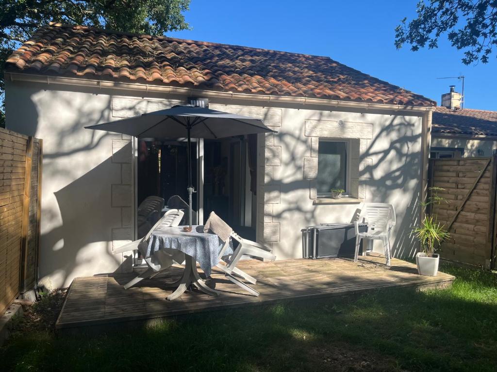 un patio avec une table, un parasol et des chaises dans l'établissement Dorian, à Pornic