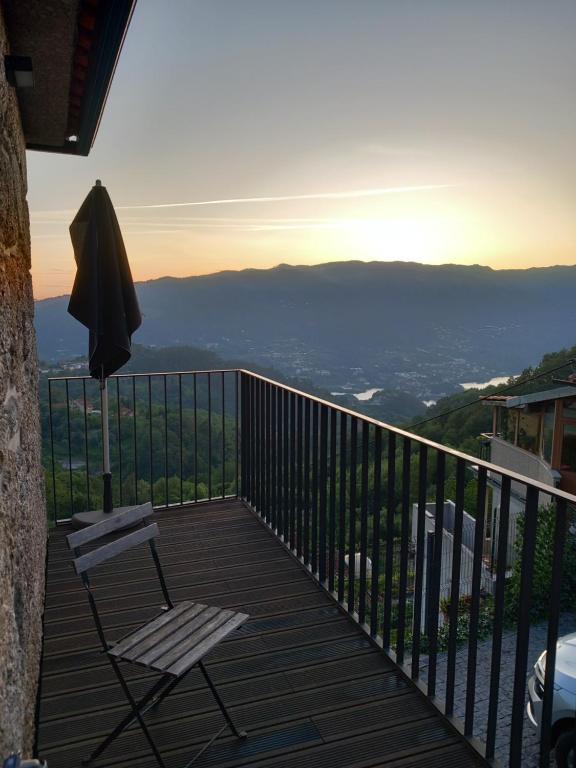 eine Terrasse mit einem Stuhl und einem Sonnenschirm auf dem Balkon in der Unterkunft Casa da Foz by Gerês Casas in Ventosa