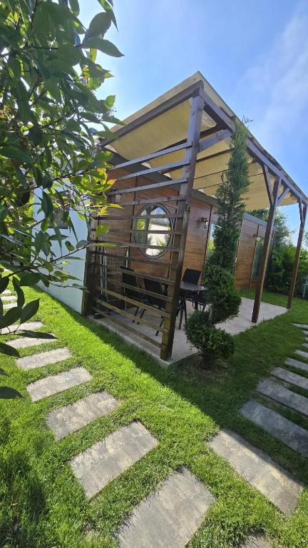 a gazebo with a bench in a yard at Tiny Village Mamaia Nord - House 1 in Mamaia Sat/Năvodari