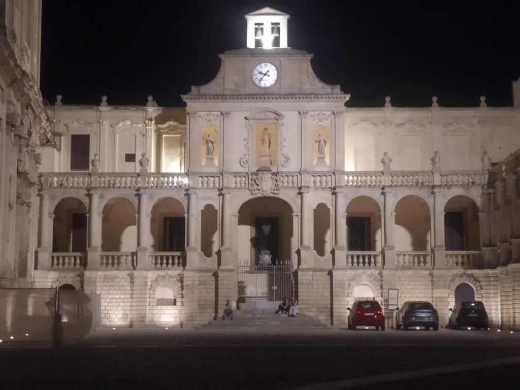 a large building with a clock tower at night at Suite Verdi in Lecce