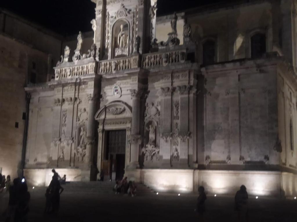 a large building with people standing outside at night at Suite Verdi suite room in Lecce