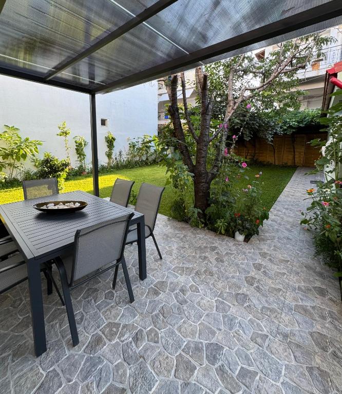 a patio with a table and chairs under a pergola at Garden House Flogita in Flogita