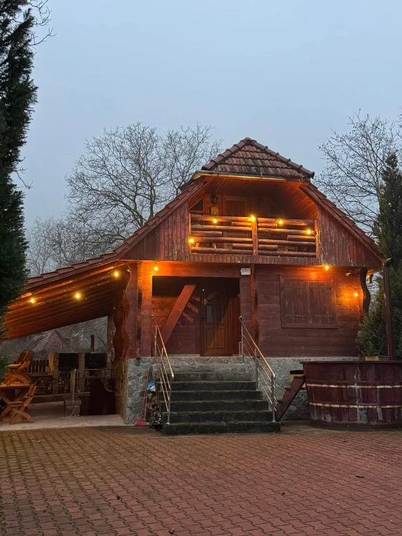 a large wooden building with stairs in front of it at Cabana Patru Anotimpuri in Rîmeţi