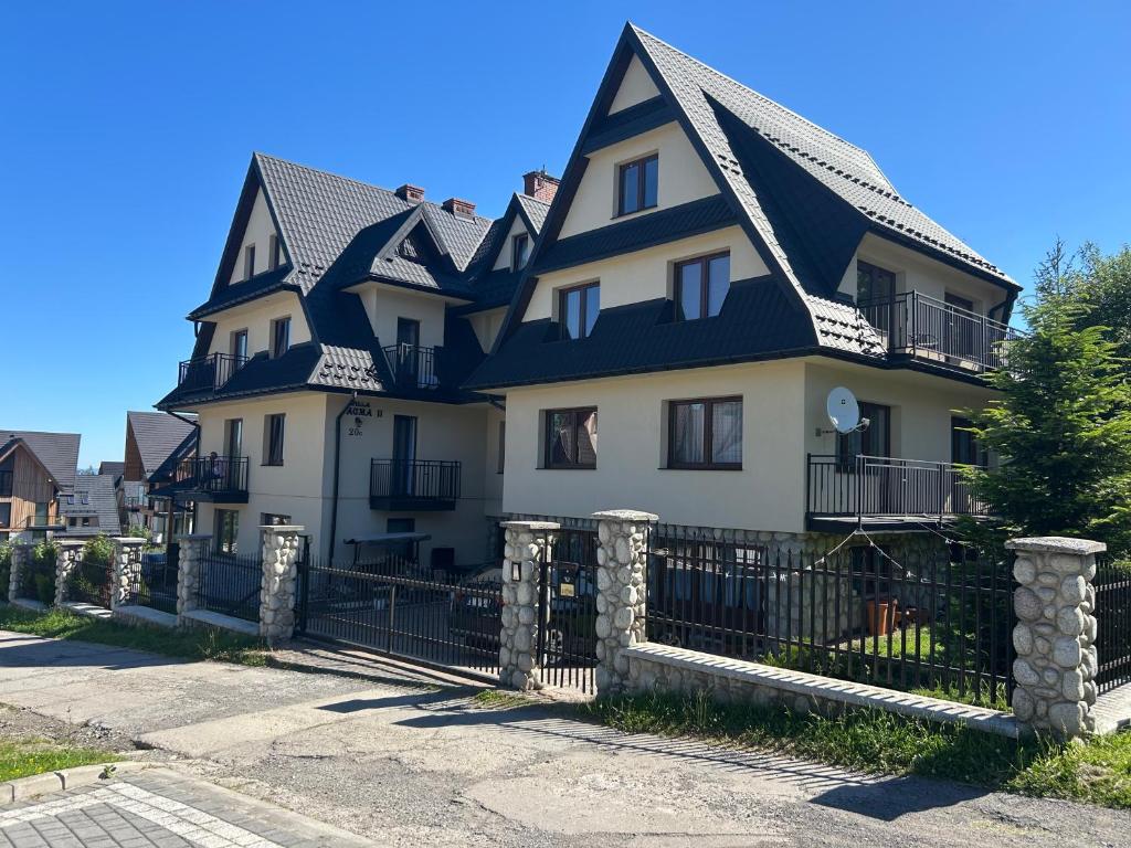 a large white house with a black roof at Willa Agma in Zakopane