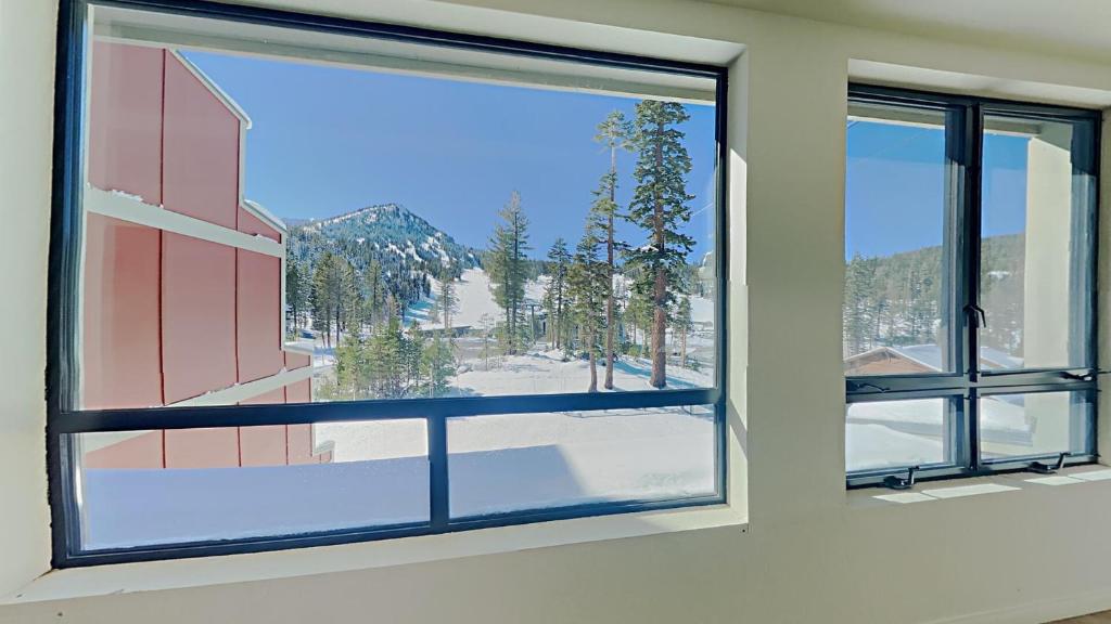 a window in a room with a view of a mountain at Comfortable Condo - Gorgeous Slopeview and Access to 3 Hot Tubs Unit 303 at 1849 in Mammoth Lakes