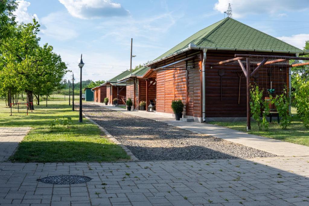 a small wooden building with a green roof at Boros Birtok 