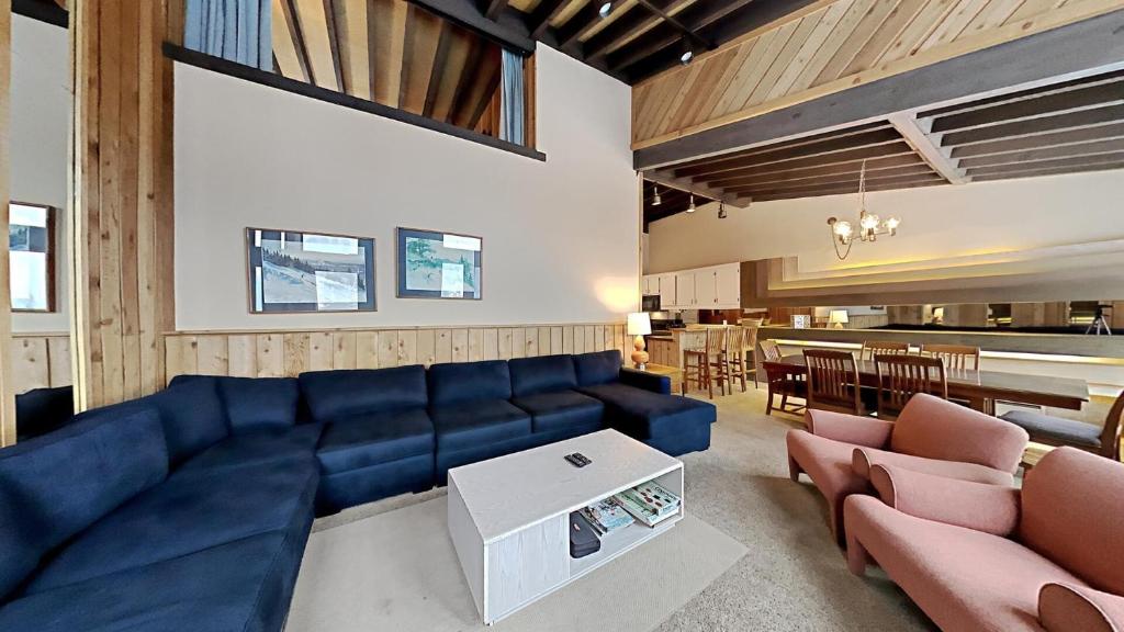 a living room with a blue couch and a table at Cozy 4-Bedroom Home with Pool and Mountain View! in Mammoth Lakes