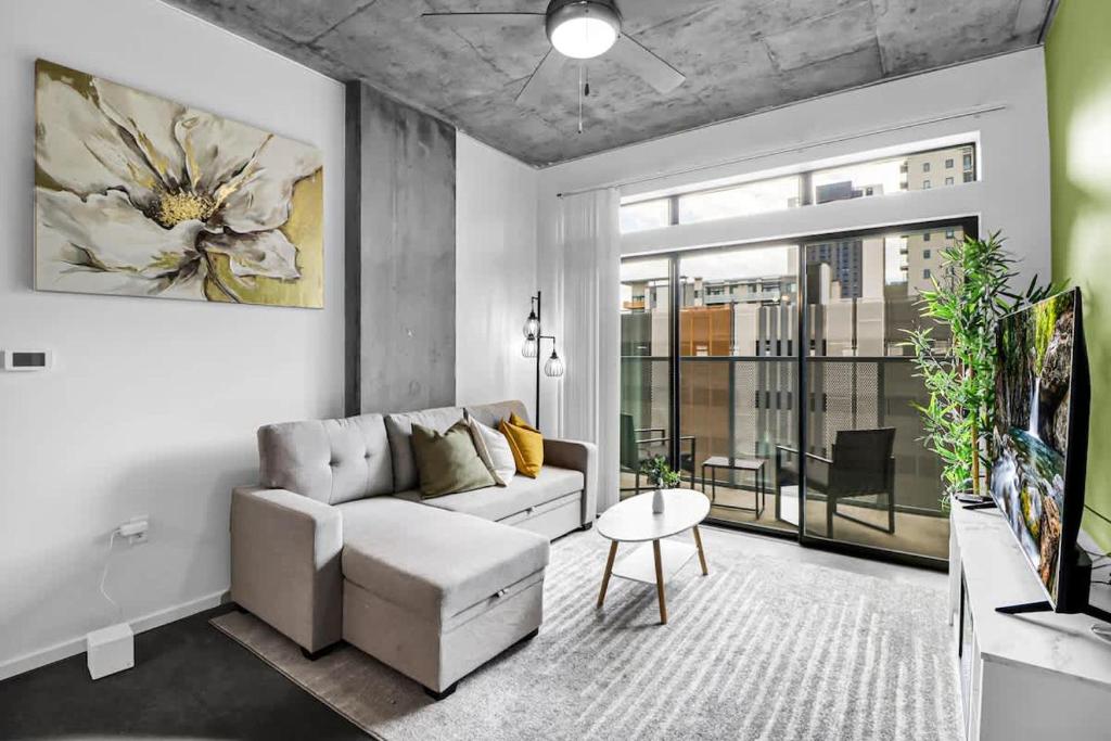 フェニックスにあるCentric 2BR In HEART of DTPHX Free Garage Parkingのソファと大きな窓のあるリビングルーム