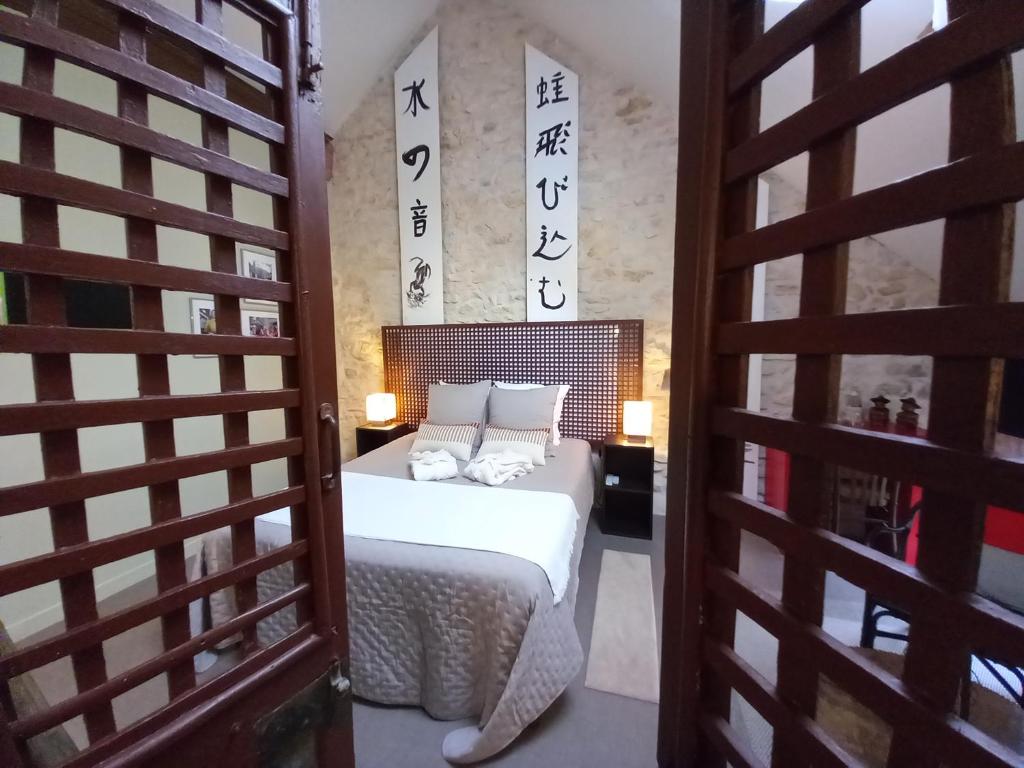 une chambre avec un lit et une porte avec un panneau dans l'établissement Aux quatre coins du monde, à Champvoux