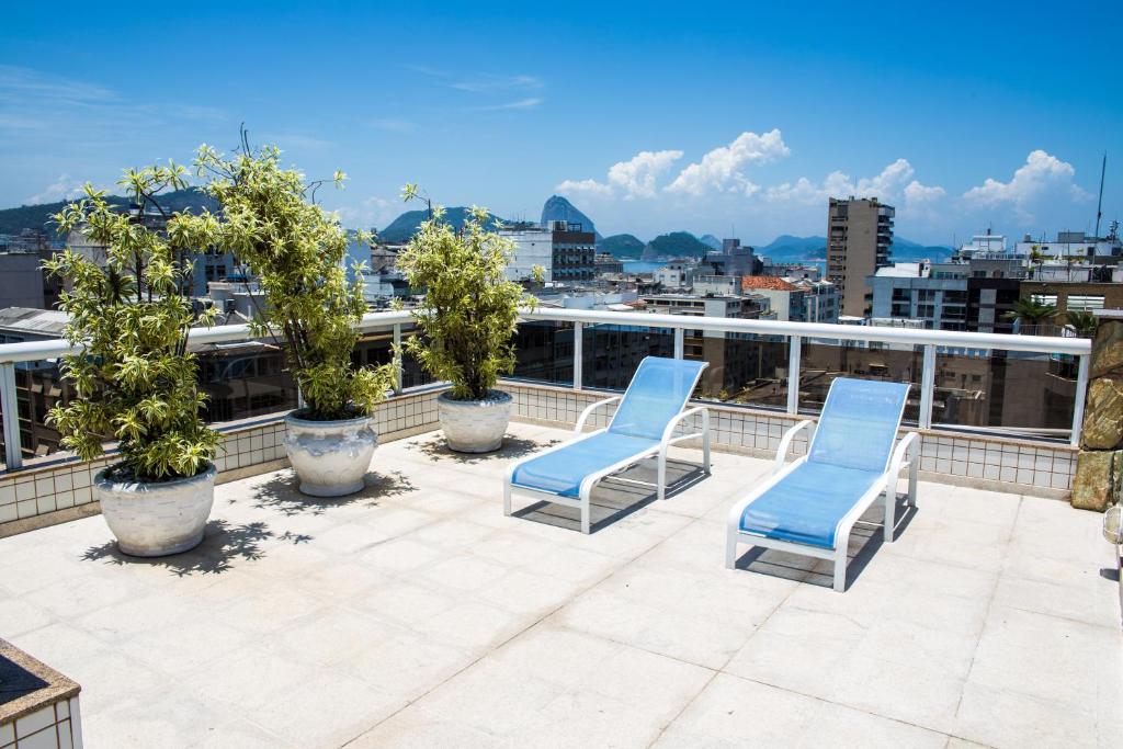 a patio with three blue chairs on a roof at Atlantis Copacabana Hotel in Rio de Janeiro