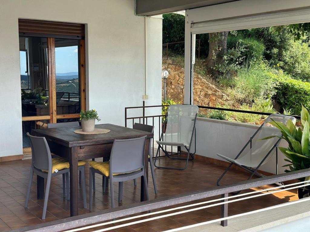 una mesa de madera y sillas en un balcón con vistas en Ferienwohnung Dolce Vita Toskana - Massa Marittima mit Parkplatz, Bikeferien meernah, en Massa Marittima