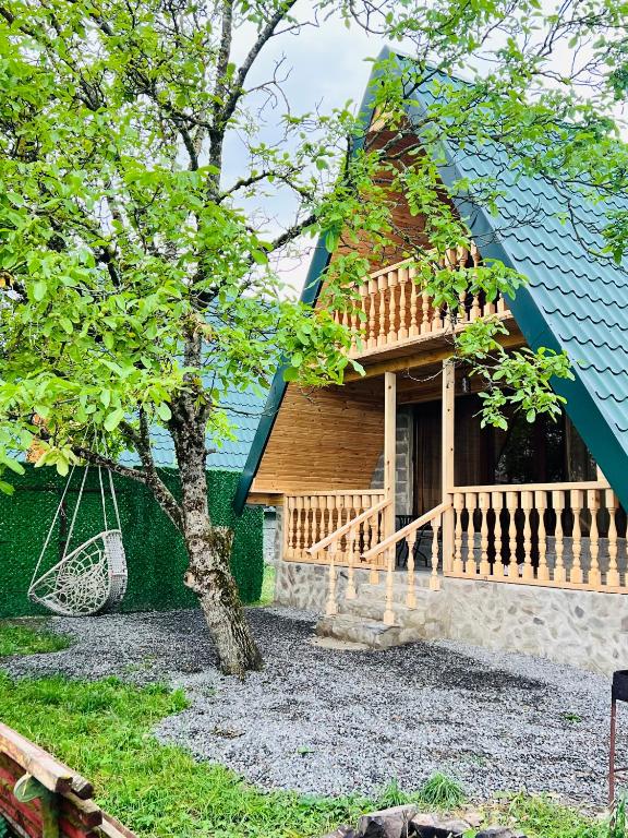 Cette maison en bois dispose d'une terrasse couverte et d'une balançoire. dans l'établissement daxuurulia dxurulia, à Itʼkhvisi