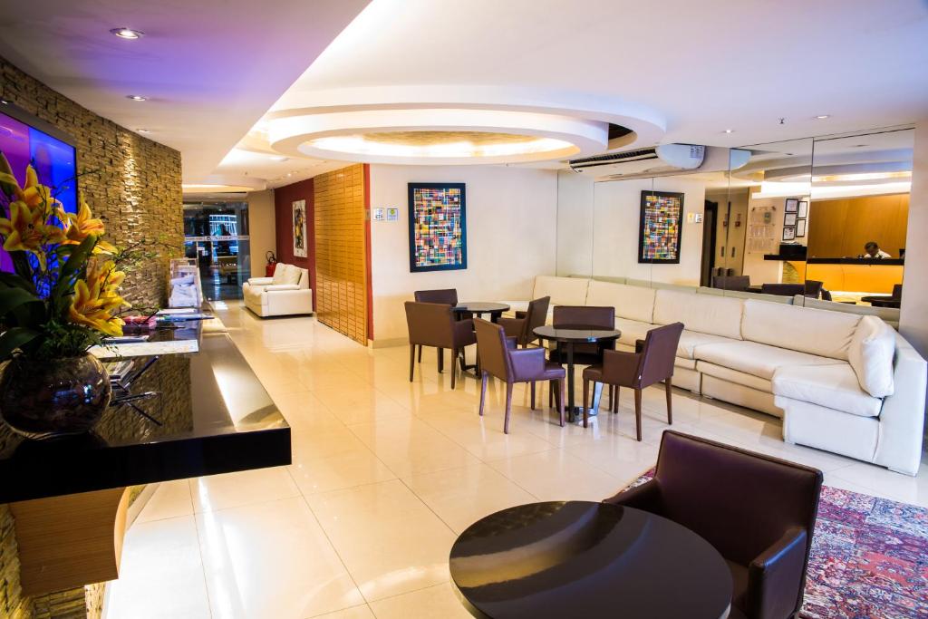 a living room with a couch and a table and chairs at Atlantis Copacabana Hotel in Rio de Janeiro