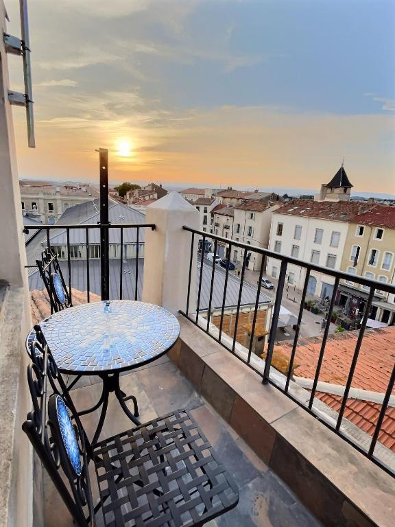 a balcony with a table and chairs and a view at Charmant duplex Béziers les Halles in Béziers