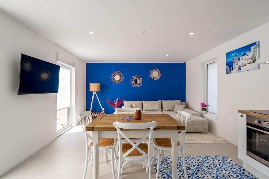 a dining room with a table and a blue wall at Duplex unique à Duppigheim 20 min de Strasbourg in Duppigheim