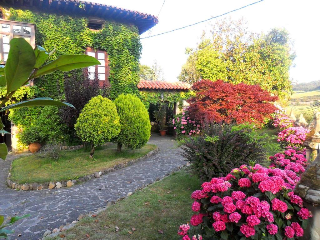 a garden with pink flowers in front of a house at Hosteria De Quijas in Quijas