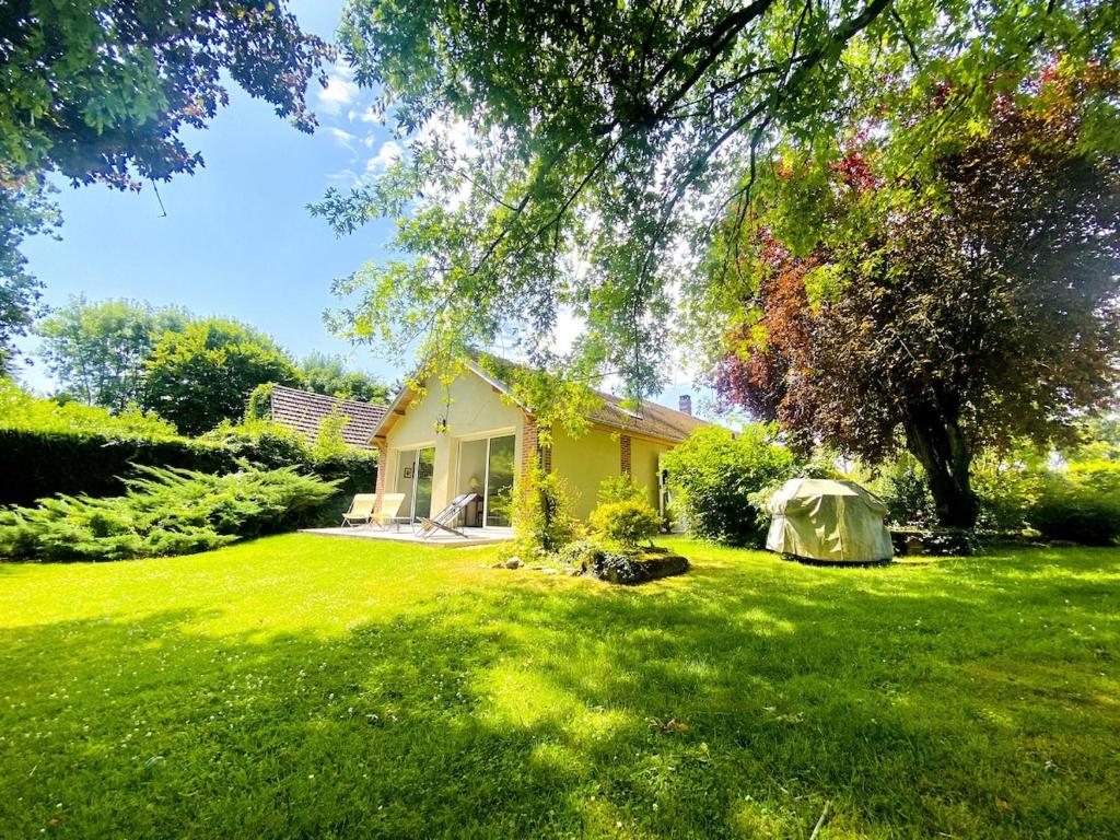 a small yellow house in a field of green grass at Nature luxuriante, jeux en famille, workation et Sauna pour 1 à 4 personnes in Labosse