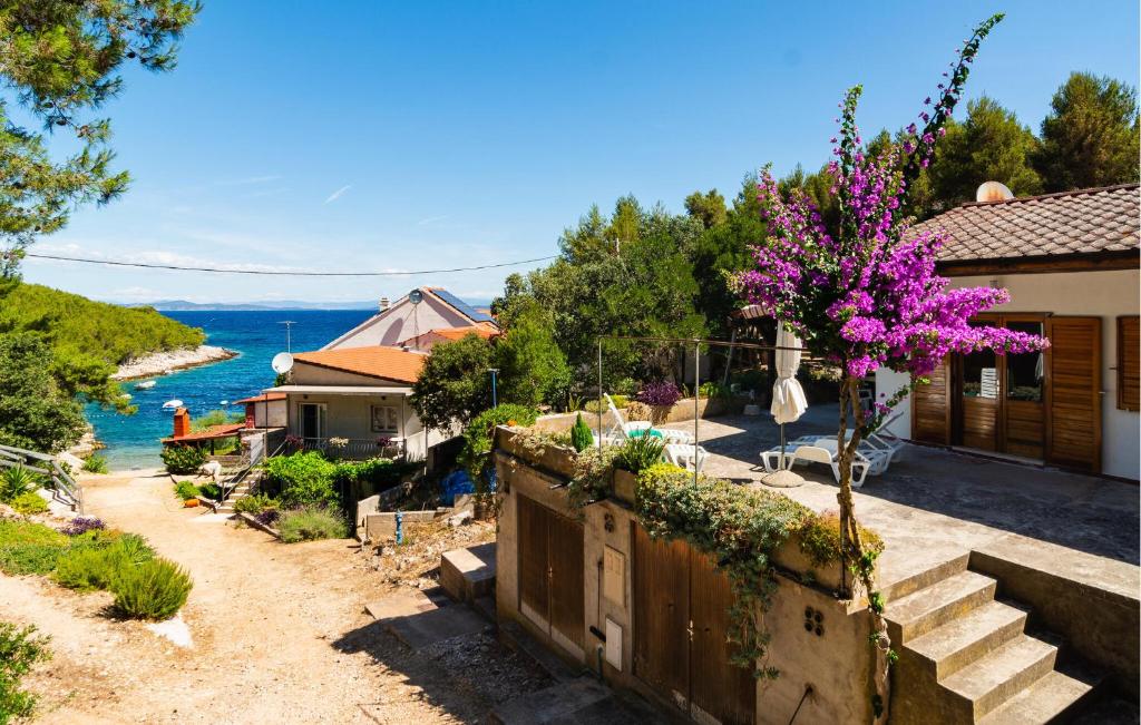 Una casa con una valla y un árbol con flores moradas. en Lovely Home In Hvar With Wifi, en Hvar