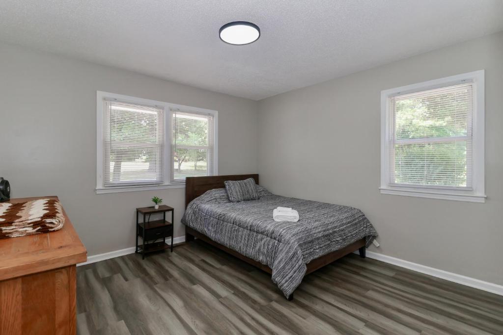 Un dormitorio con una cama y dos ventanas. en Tillery Trail Retreat Mount Gilead, en Mount Gilead