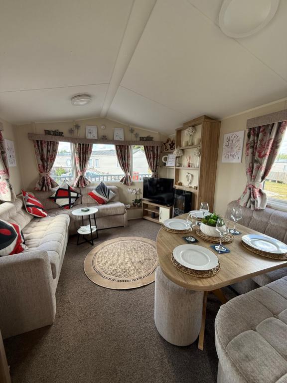 a living room with a table and couches at Andreas Fir Trees Retreat at 7 Lakes Country Park in Crowle