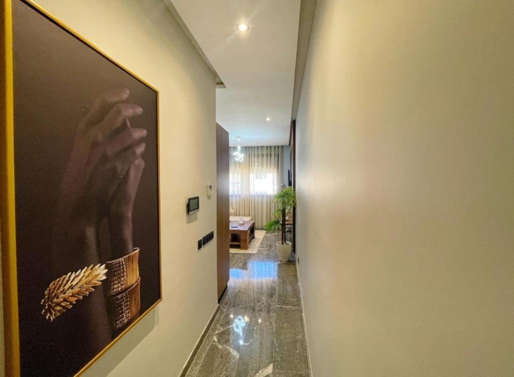 a hallway with a painting of a hand on the wall at Luxury Modern Studio with Netflix, Kitchen and Free Parking Elite Garden, Marrakesh in Aït Saïd