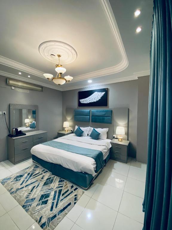 a bedroom with a large bed and two night stands at شقق ترخيص ضيافة خاصة في الدور الأول لايوجد مصعد in Khamis Mushayt