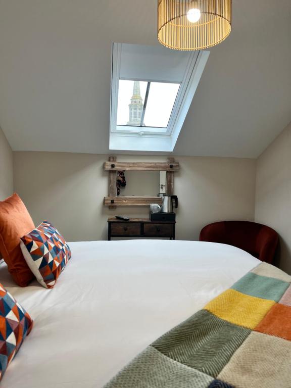 a bedroom with a white bed with a window at The courtyard bar, kitchen, rooms in Moffat