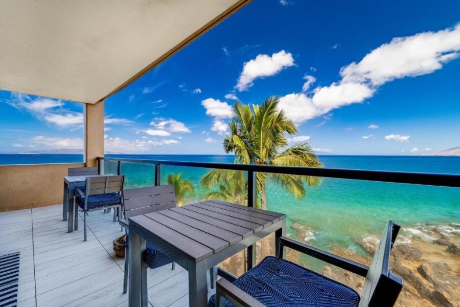 a table and chairs on a balcony overlooking the ocean at KIHEI SURFSIDE, #501 condo in Wailea