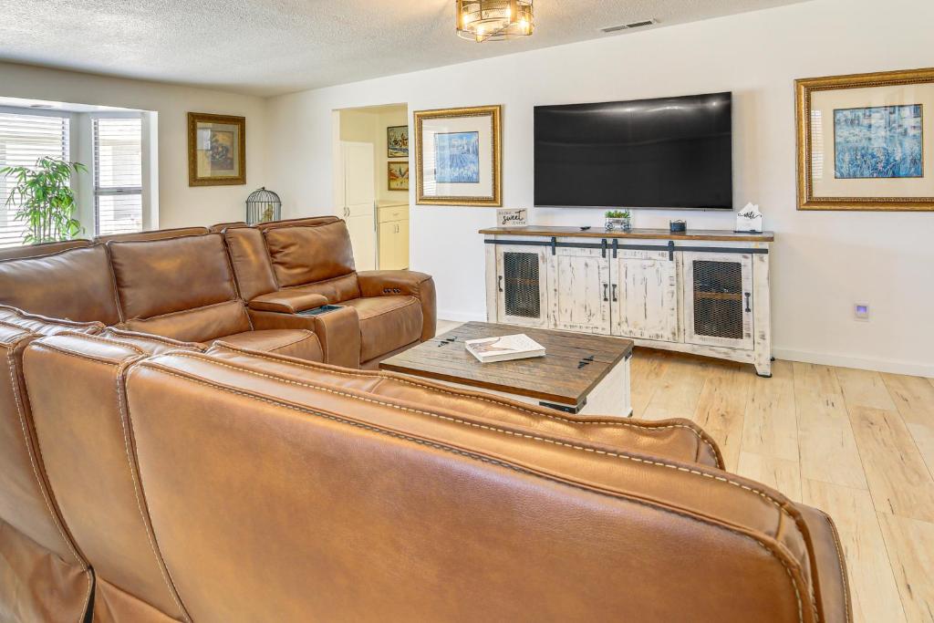 a living room with a couch and a flat screen tv at 9 Mi to Joshua Tree NP Yucca Valley Home with Pool in Yucca Valley