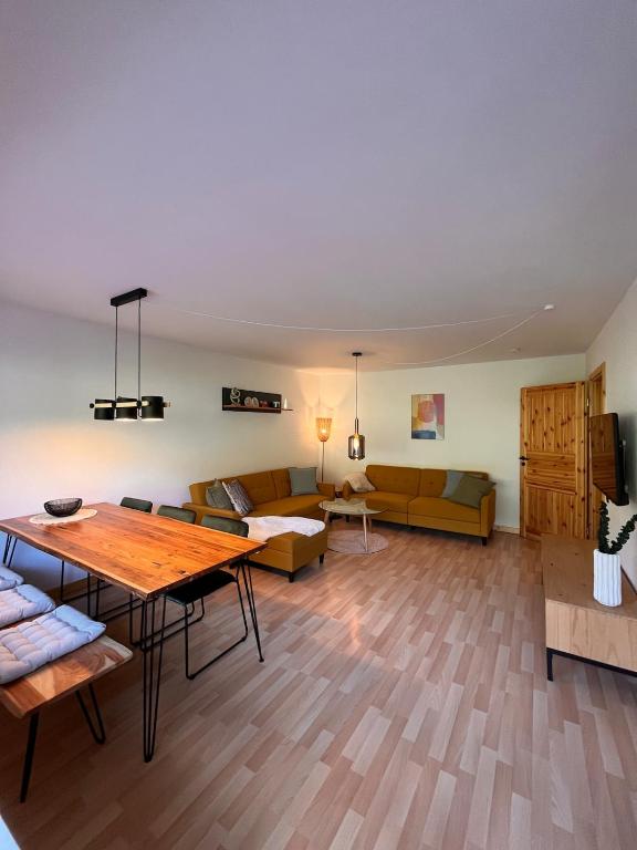 a living room with a table and a couch at Die Ente an der Enz, mit Schwimmbad und Sauna in Bad Wildbad