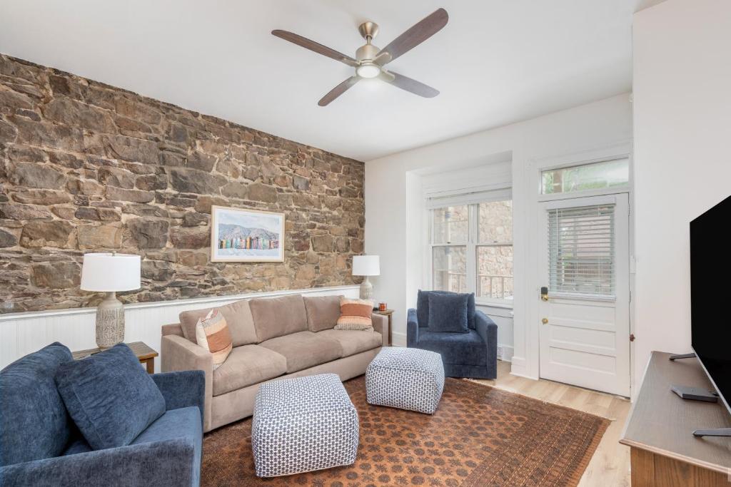 a living room with a couch and a brick wall at Stone Alley Condo condo in Telluride