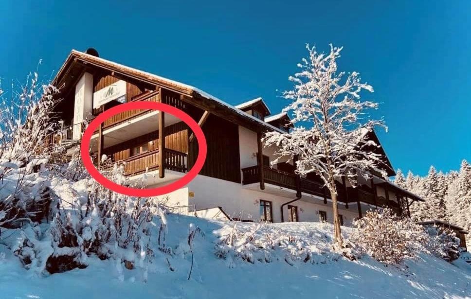 a house in the snow with a red circle in front at Aotearoa - Mountain apartment in Bavaria, Mitterdorf - Mitterfirmiansreut in Mitterfirmiansreut