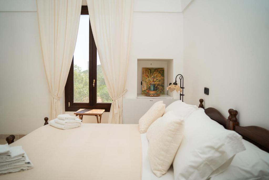 una camera bianca con letto e cuscini bianchi di Villa Castrignano a Monopoli