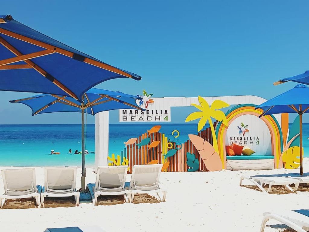 a beach with chairs and umbrellas on the beach at العالمين in El Alamein