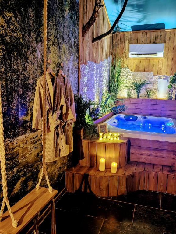 un jacuzzi dans une chambre avec un peignoir et des bougies dans l'établissement Les Spas de la mer, Appart&Spa Canopée, 100m de la plage, Love Room, au Grau-du-Roi