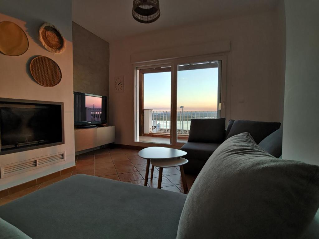 ein Wohnzimmer mit Sofa und Fernseher in der Unterkunft Chalet 3 hab vista rio Guadiana in Ayamonte