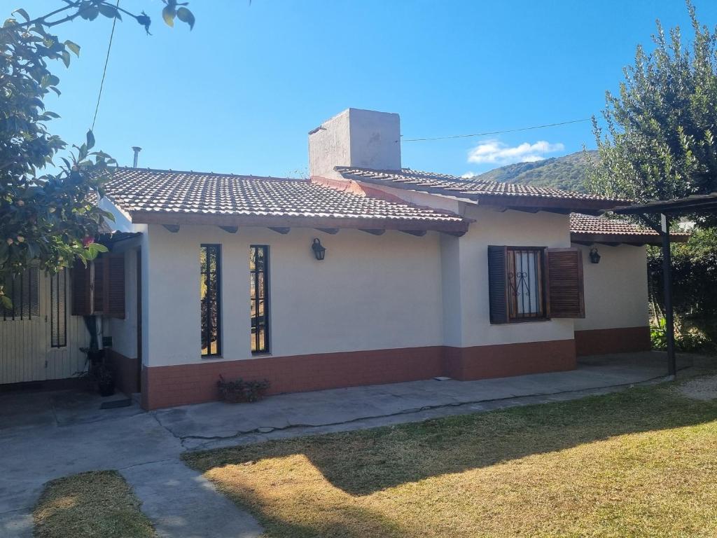 a small white house with a red roof at Las Camelias - chalet zona centro, aerosillas in Villa Carlos Paz