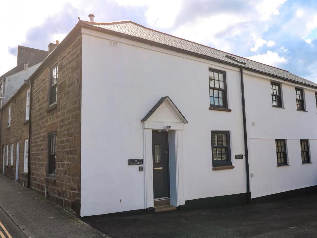 een wit gebouw met een deur aan de zijkant bij 21 Alverton Street in Penzance