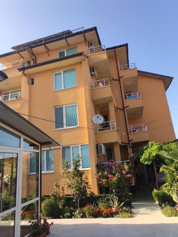 a building with balconies and flowers in front of it at стаи за гости Левтерови in Chernomorets
