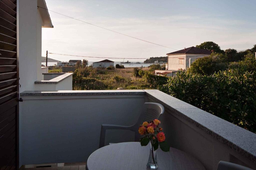 ロパールにあるApartments in Lopar - Insel Rab 17729のバルコニーにテーブルと花瓶