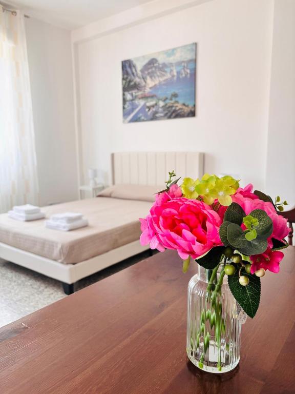 a vase of flowers on a table in a bedroom at Maison Du Soleil in Somma Lombardo