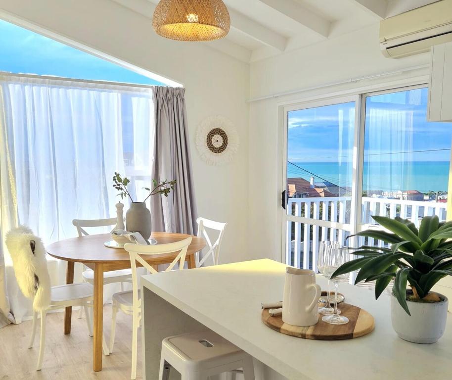 a kitchen and dining room with a view of the ocean at Sea View Oamaru in Oamaru