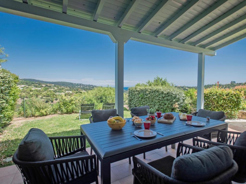 une table bleue et des chaises sur une terrasse avec vue dans l'établissement Les Collines, aux Issambres
