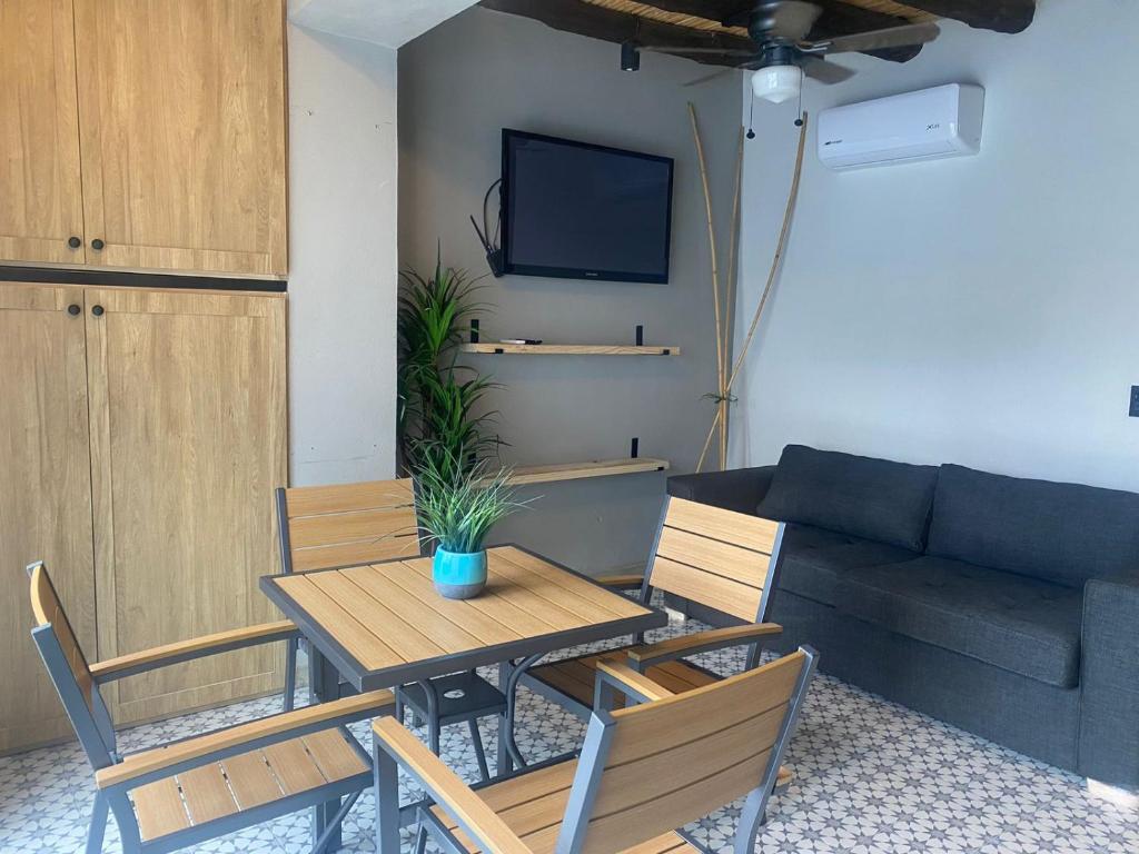 Una sala de estar con una mesa y sillas y un sofá. en Casa Sererno I, en Cuatrociénegas de Carranza