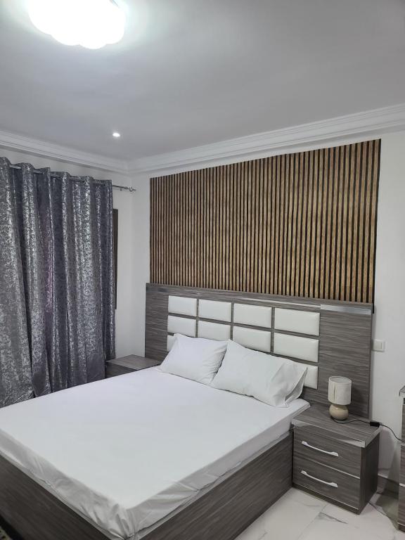 a bedroom with a large white bed and a window at Zeynab appt mamelles in Dakar