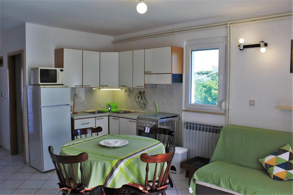 a small kitchen with a table and a green couch at Apartment Eni in Rovinj